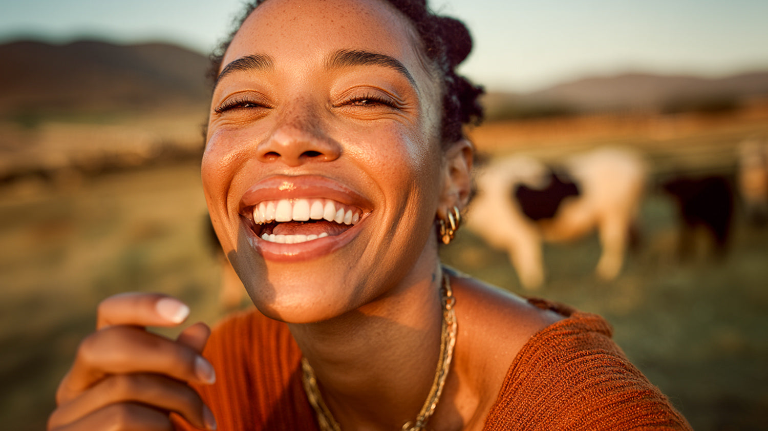 Woman smiling with cows in the background